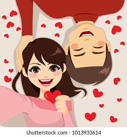 Cute young couple making selfie together lying on floor celebrating Saint Valentine day