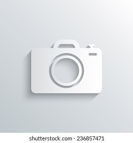 Cutout paper background. Photo camera sign icon. Digital photo camera symbol. White poster with icon. Vector