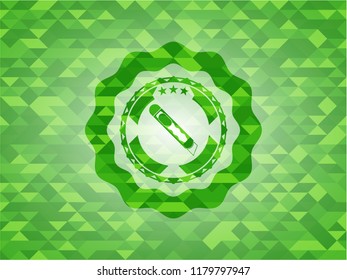 cutter icon inside green emblem with triangle mosaic background
