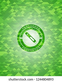 cutter icon inside green emblem with mosaic ecological style background