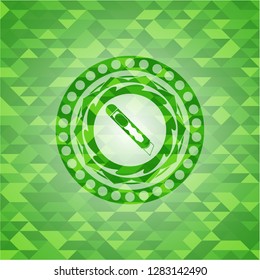 cutter icon inside green emblem with mosaic background