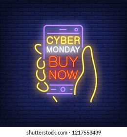 Cyber Monday buy now neon sign. Mobile phone in human hand with bright inscription on dark blue brick background. Can be used for topics like shopping, mobile, online shopping, sales