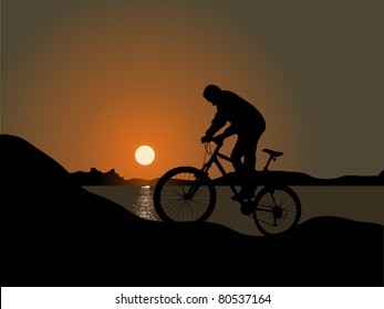 Cyclist by the sea in the sunset