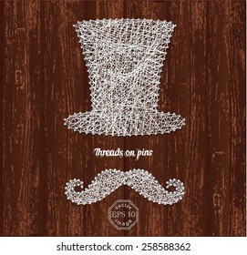 Cylinder and mustache silhouettes made with white thin ropes and pins on wooden background