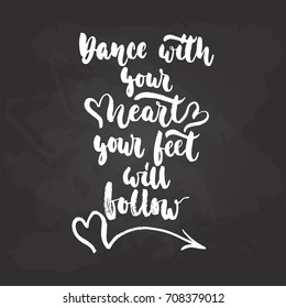 Dance with your heart your feet will follow - lettering dancing calligraphy quote drawn by ink in white color on the black chalkboard background. Fun hand drawn lettering inscription
