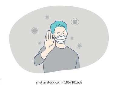 Danger or coronavirus infection epidemic, protective facial mask, pandemic concept. Young man in medical protective mask standing and showing stop protection sign with hand in corona bacteria flow