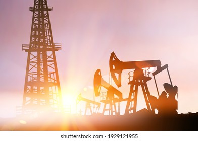 Darck silhoutte of oil rig and pumps during sunset