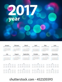 Dark blue 2017 year calendar with blue bokeh, week starts on Sunday 