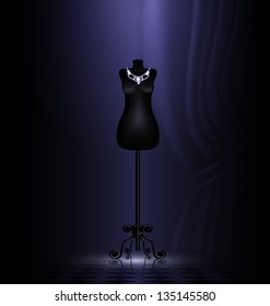in dark room is black craft dummy with jewelry necklace