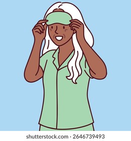 Dark skinned elderly woman with white hair puts on sleeping mask and gets ready for bed, enjoying her night routine in calm mood
