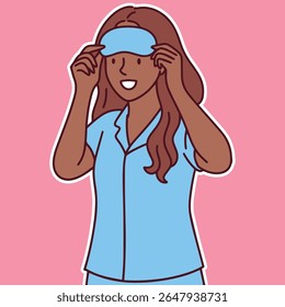 Dark skinned woman in blue pajamas puts on sleeping mask and prepares for calm and restful night routine