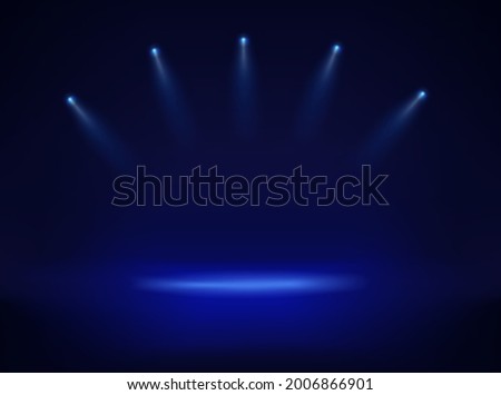 Dark srudio and four blue projectors pointed to the center
