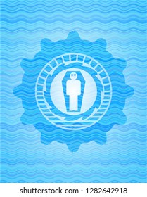 dead man in his coffin icon inside water wave badge.