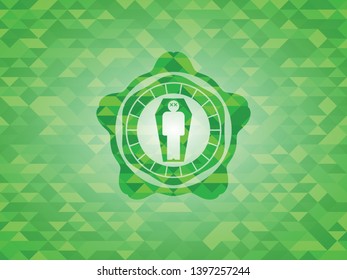 dead man in his coffin icon inside green emblem with triangle mosaic background