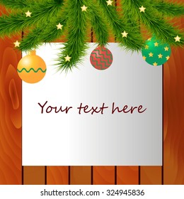 Decorated Christmas tree branches on top of wood background