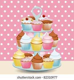 Decorated cupcakes on a stand with a polka dot background svg