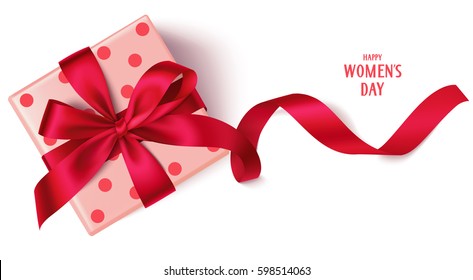 Decorative gift box with red bow and long ribbon. Happy Women's Day text. Top view