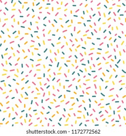 Decorative party sprinkles seamless repeat vector pattern. Blue, yellow, and pink candy kids party decor on white background. Great for birthday, card, invitation, packaging, celebration, kids, bakery