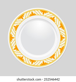 Decorative plate with patterned border, on gray background, top view.