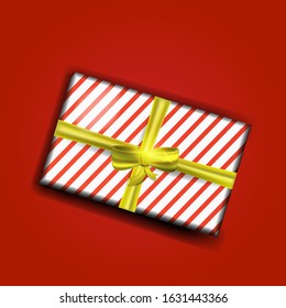 Decorative realistic vector gift box with a  bow and a  ribbon.