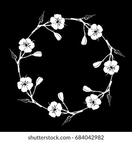 Decorative round frame with apricot spring blossom. White silhouette on black background. Design element, framework, emblem.
