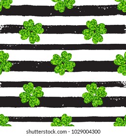 Decorative seamless pattern with black lines and green clover leaves on a white background. Design for St. Patrick's Day. 