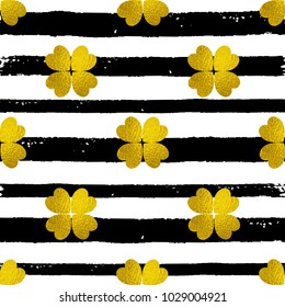 Decorative seamless pattern with black lines and golden clover leaves on a white background. Design for St. Patrick's Day. 