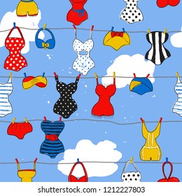 Decorative seamless pattern with swimsuits. Dry brush painted swimwear, trendy texture. Hand drawn endless stylish backdrop. Colorful beachwear on cloudy sky background for fabric, wallpaper, wrapping