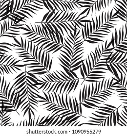 Decorative tropical seamless pattern with black palm leaves on a white background