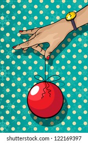 Decorative winter holidays card of a hand holding a Christmas tree decoration.