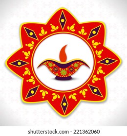 Deepawali celebration with colorfull rangoli and illuminated oil lit lamp on white.