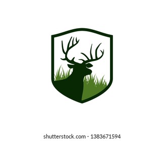 deer head with antlers in front of meadow grass inside crest shield logo