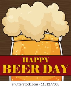 Delicious frothy and bubbly beer over a wooden background and a greeting ribbon to celebrate Beer Day.