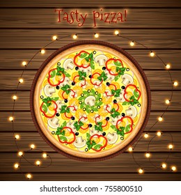 Delicious pizza on a wooden table with a bright garland.