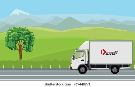 Delivery truck passing by beautiful landscape on the road.