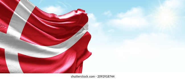 Denmark flag in the blue sky. Horizontal panoramic banner.