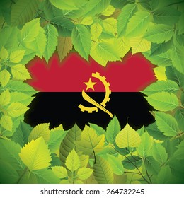 Dense, green leaves over the flag of Angola