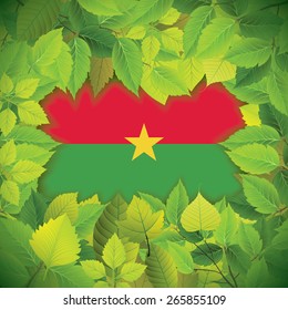 Dense, green leaves over the flag of Burkina Faso