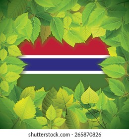 Dense, green leaves over the flag of Gambia