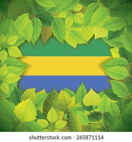 Dense, green leaves over the flag of Gabon
