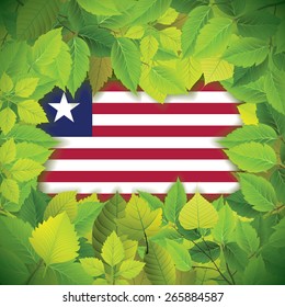 Dense, green leaves over the flag of Liberia