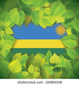 Dense, green leaves over the flag of Rwanda