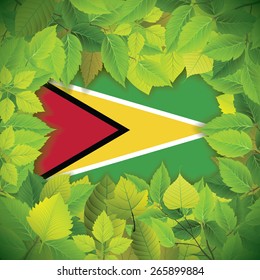 Dense, green leaves over the flag of Guyana