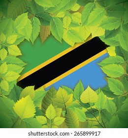 Dense, green leaves over the flag of Tanzania