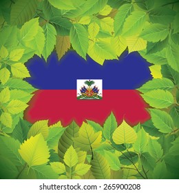 Dense, green leaves over the flag of Haiti