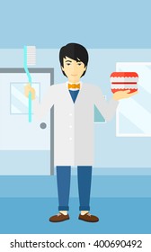 Dentist with dental jaw model and toothbrush.