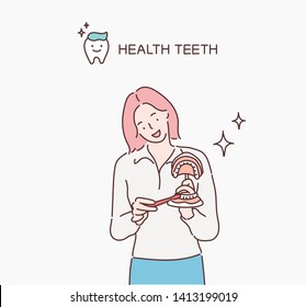 Dentist showing on a jaw model how to clean the teeth with tooth brush properly and right. Hand drawn style vector design illustrations.