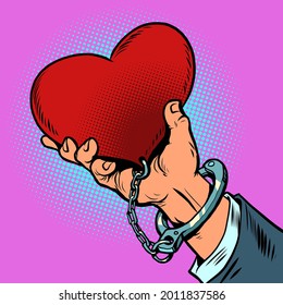 dependencia del amor. el corazón rojo está esposado a la mano del hombre. Día de San Valentín