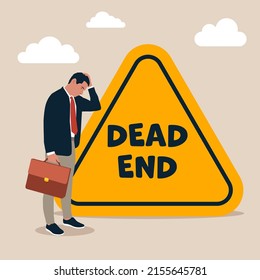 Depressed businessman office worker stop at dead end road sign. Business or career dead end, no solutions or other work around for business obstacle, risk of struggle at the same job for years concept
