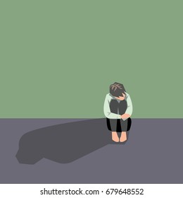 Depressed man sit and  hugging his knees. Concept of sad people